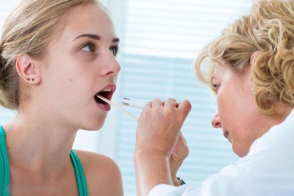 Sinusuri ng doktor ang oral cavity para sa pagkakaroon ng mga papilloma